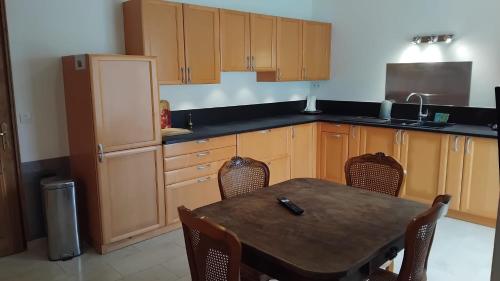 une cuisine avec une table, des chaises et un réfrigérateur dans l'établissement Belle Maison à MESLAND, à Mesland