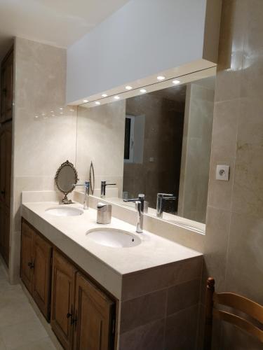 une salle de bain avec deux lavabos et un grand miroir dans l'établissement Belle Maison à MESLAND, à Mesland