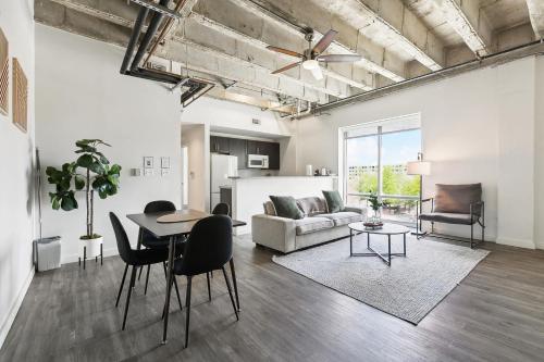 a living room with a table and a couch at Industrial Downtown Apartment - 2BD 2BA in Baton Rouge