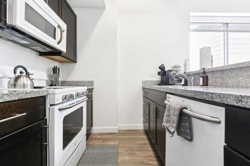 a kitchen with a stove and a microwave at Industrial Downtown Apartment - 2BD 2BA in Baton Rouge
