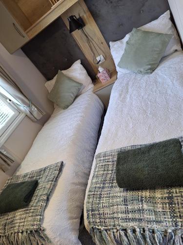 two beds sitting next to each other in a room at 2 Borwick Lakes in Carnforth
