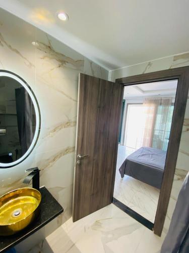 a bathroom with a sink and a mirror and a bed at La Cascade Ḩammām al Ghazzāz in Kelibia