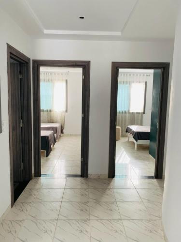 a room with two beds and two mirrors at La Cascade Ḩammām al Ghazzāz in Kelibia