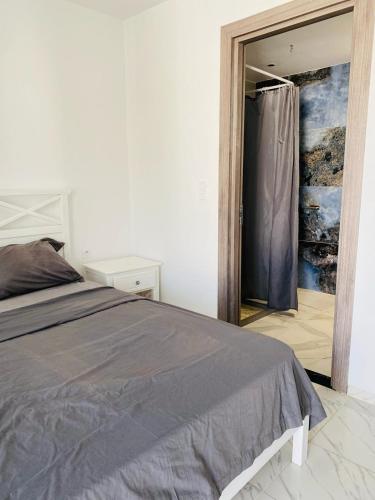 a bedroom with a bed and a door leading into a room at La Cascade Ḩammām al Ghazzāz in Kelibia