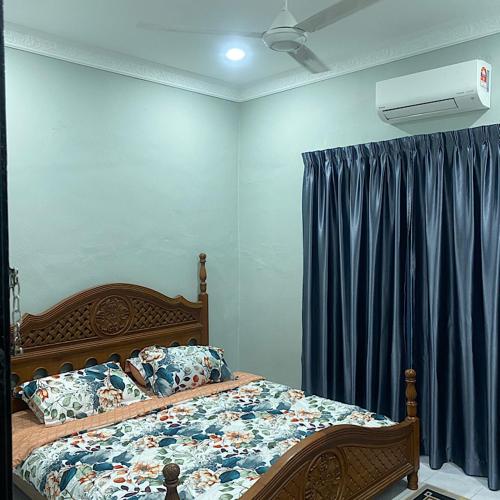 Gua SaiにあるDarainhomestayのベッドルーム(ベッド1台、青いカーテン付)