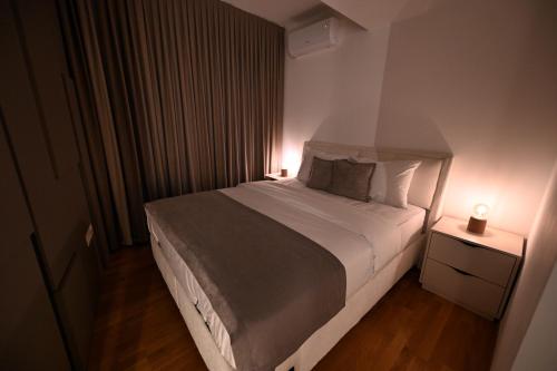 a bedroom with a large bed with two lamps on it at Creamy Dreams by Dazzie in Skopje