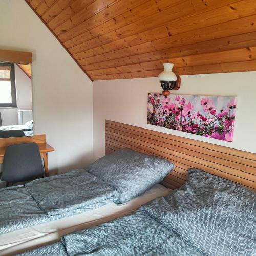 a bedroom with a bed and a painting on the wall at Balaton Garden in Balatongyörök