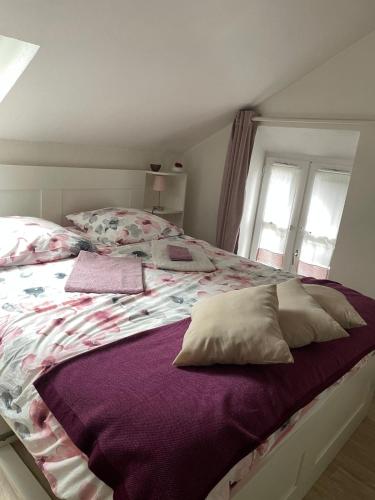 - une chambre avec un lit doté de draps et d'oreillers violets dans l'établissement Halte entre Terre et Mer à Bayeux, à Bayeux