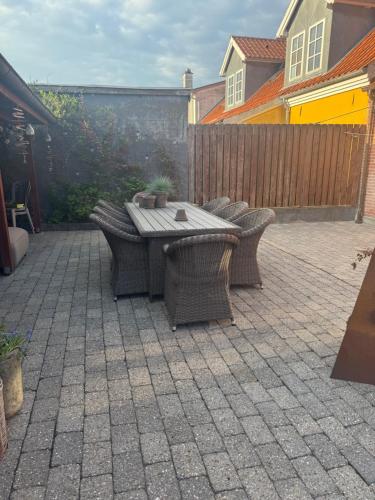 a patio with a table and chairs and a fence at Svane's Air-bnb in Nykøbing Mors