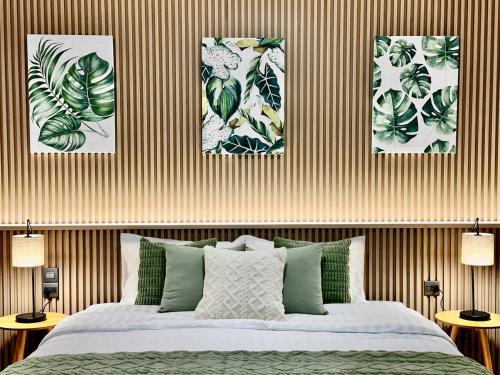 a bedroom with four pictures of plants on the wall at Serene Escape 2 mins from SRT Wat Samien Nari in Bangkok