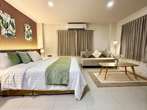 a bedroom with a large bed and a couch at Serene Escape 2 mins from SRT Wat Samien Nari in Bangkok