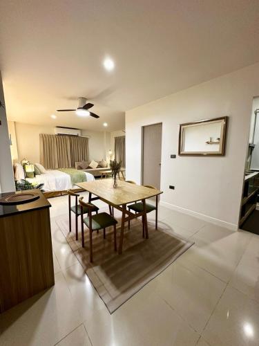 a living room with a table and a bedroom at Serene Escape 2 mins from SRT Wat Samien Nari in Bangkok