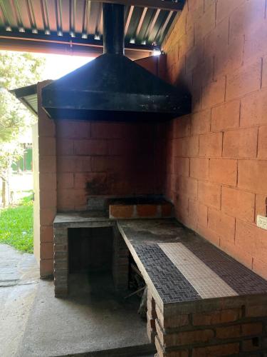 an outdoor grill with a bench in a brick wall at Casa de Campo La Gloria Ataco in Concepción de Ataco