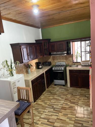 a kitchen with wooden cabinets and a stove at Casa de Campo La Gloria Ataco in Concepción de Ataco