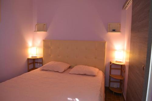 - une chambre avec un lit avec deux oreillers et deux lumières dans l'établissement Mimosa, aux Lecques