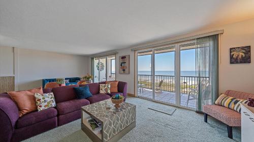 a living room with a purple couch and a balcony at Gulf View Escape in Siesta Key