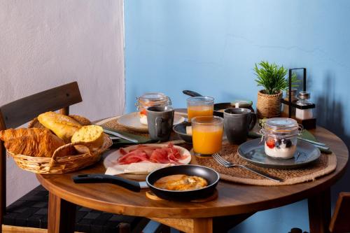 a wooden table topped with breakfast foods and orange juice at Casa Vista in Canillas de Albaida