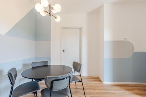a dining room with a black table and chairs at - NumberZ - Rooms Apartments and Suites with Wi-Fi and AC in Borgo Isonzo