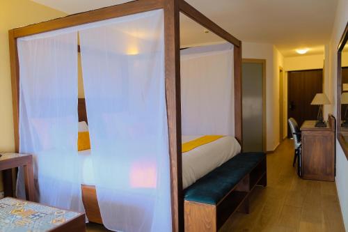 a bedroom with a canopy bed with a blue bench at HAMILTON Agadir in Agadir