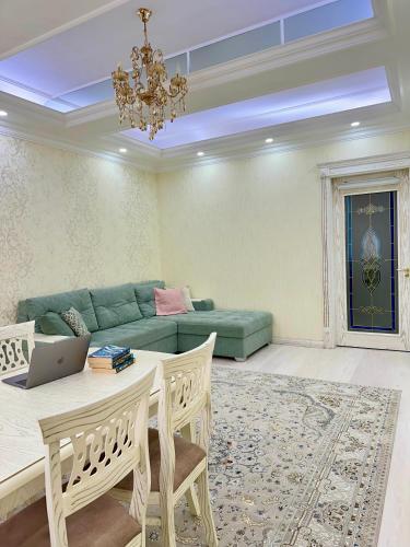 a living room with a couch and a table with a laptop at Nordic Style Apartment in Fergana