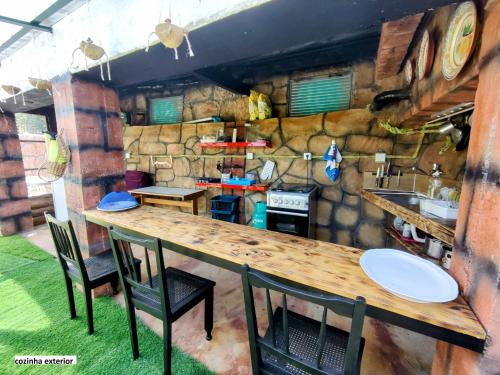 a kitchen with a long wooden table and chairs at QT 8 -Casa Amazonia Portugal in Cernache