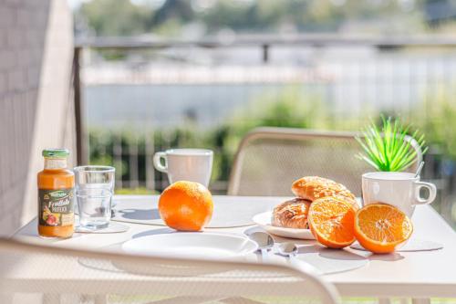 a table with a plate of oranges and two cups at - NumberZ - Rooms Apartments and Suites with Wi-Fi and AC in Borgo Isonzo