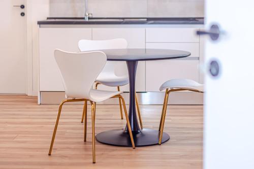 a table and two white chairs in a kitchen at - NumberZ - Rooms Apartments and Suites with Wi-Fi and AC in Borgo Isonzo
