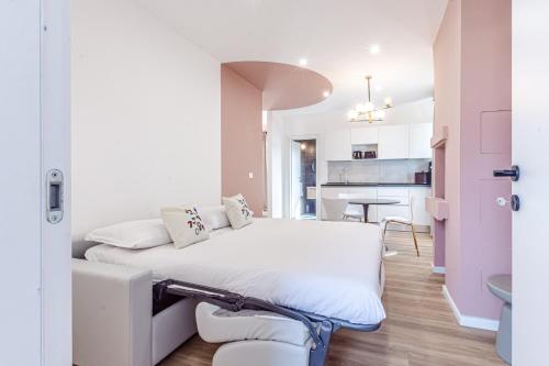 a bedroom with a white bed and a kitchen at - NumberZ - Rooms Apartments and Suites with Wi-Fi and AC in Borgo Isonzo