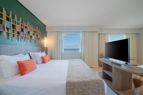 a bedroom with a large bed with a flat screen tv at Beach Park Resort - Oceani in Aquiraz