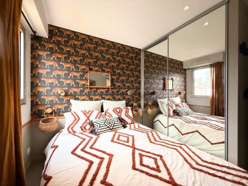 une chambre avec deux lits et un grand miroir dans l'établissement Appartement cosy avec balcon, 1 chambre à Sainte Maxime, à Sainte-Maxime