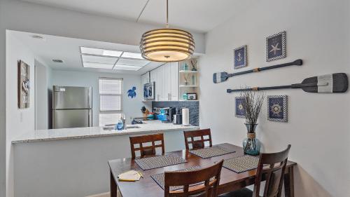 a dining room with a table and chairs and a kitchen at Its a Shore Thing in Longboat Key