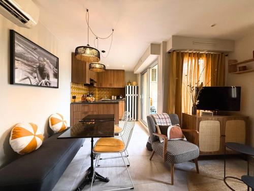 un salon avec un canapé, une table et des chaises dans l'établissement Appartement cosy avec balcon, 1 chambre à Sainte Maxime, à Sainte-Maxime