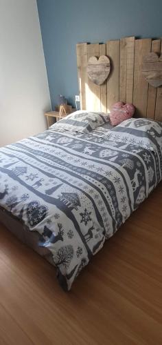 - un lit avec une couverture noire et blanche dans l'établissement Le Meix du Lac 3 étoiles - 200 m du lac - 50 m navette ski, à Gérardmer