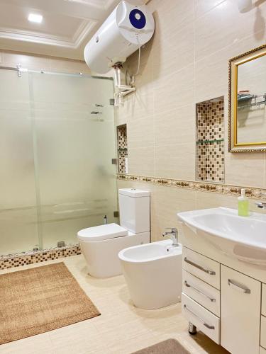 a bathroom with a sink and a toilet and a shower at Nordic Style Apartment in Fergana