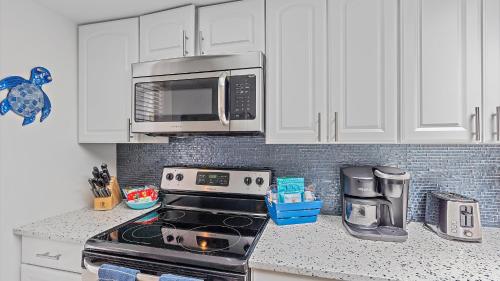 a kitchen with a stove and a microwave at Its a Shore Thing in Longboat Key