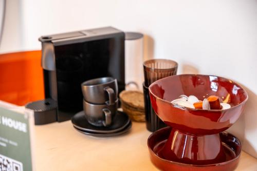 a red bowl on a counter next to a coffee maker at THE BLUE HOUSE - Guest Suite 1 in Bruges