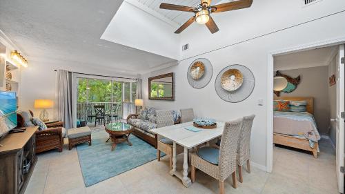 a living room with a ceiling fan and a table at Just Beachy in Longboat Key