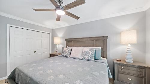 a bedroom with a bed and a ceiling fan at Just Beachy in Longboat Key