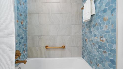 a bathroom with a shower with blue tiles at Just Beachy in Longboat Key
