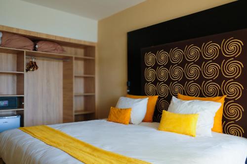 a bedroom with a large white bed with yellow pillows at HAMILTON Agadir in Agadir