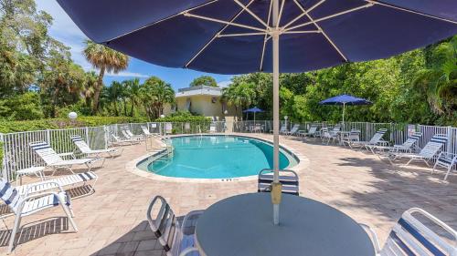 a table with an umbrella next to a pool at Just Beachy in Longboat Key