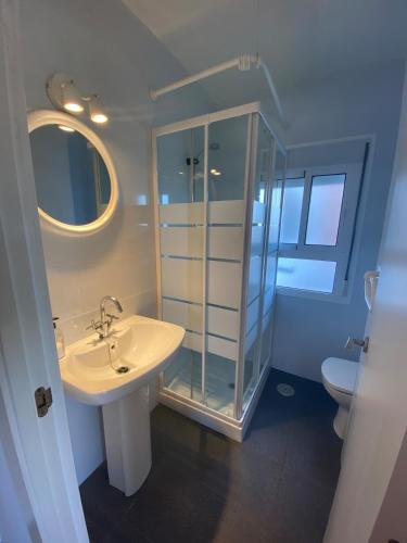 a bathroom with a sink and a glass shower at Loft cerca de la playa in Punta Umbría