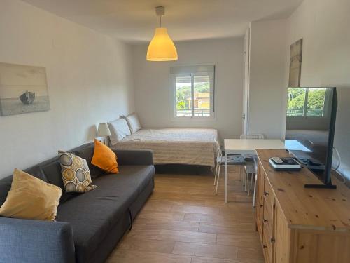 un soggiorno con un divano e un letto di Loft cerca de la playa a Punta Umbría