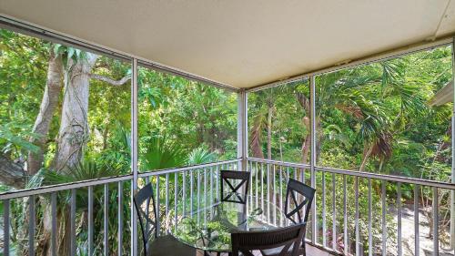 two chairs on a balcony with trees in the background at Just Beachy in Longboat Key