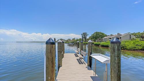 a wooden dock with benches on the water at Just Beachy in Longboat Key