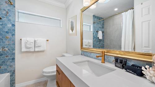 a bathroom with a sink and a toilet and a mirror at Just Beachy in Longboat Key