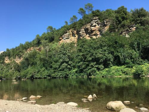 une rivière avec des rochers et une montagne en arrière-plan dans l'établissement Camping le mas du serre, à Gravières
