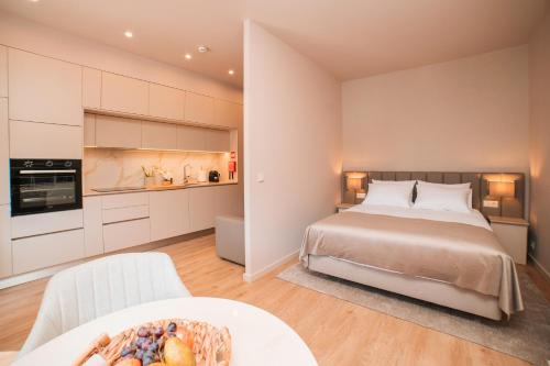a bedroom with a large bed and a kitchen at Casa Monteiro by Quantique in Braga