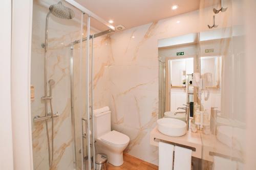 a bathroom with a shower and a toilet and a sink at Casa Monteiro by Quantique in Braga