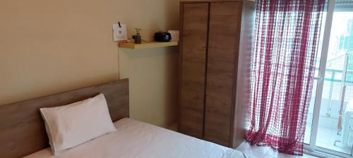 a bedroom with a bed and a window with curtains at Cozy and quiet apartment at the center of the city in Komotini